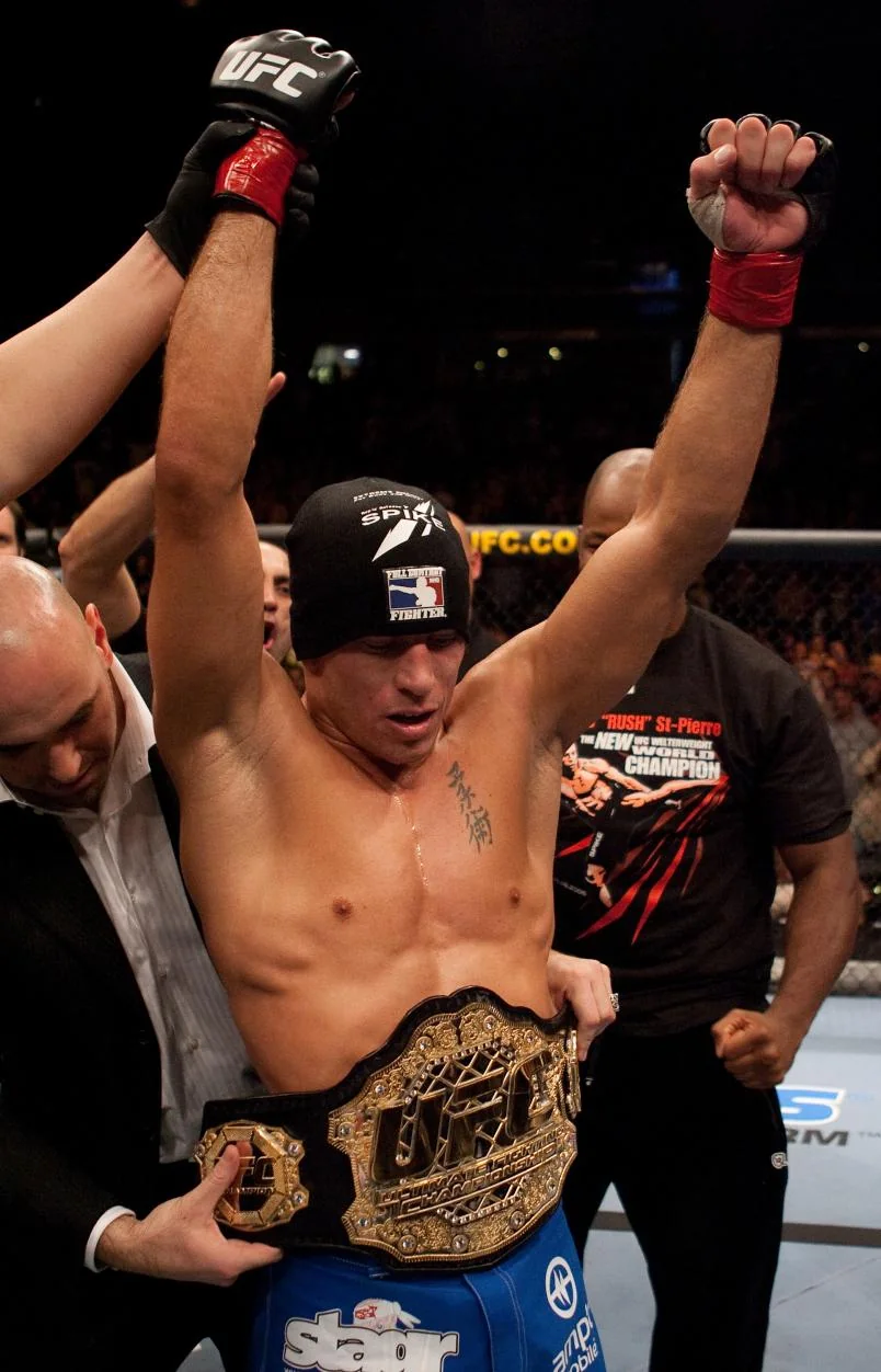 Georges St-Pierre celebrates with the welterweight championship after beating Matt Hughes at UFC 65
