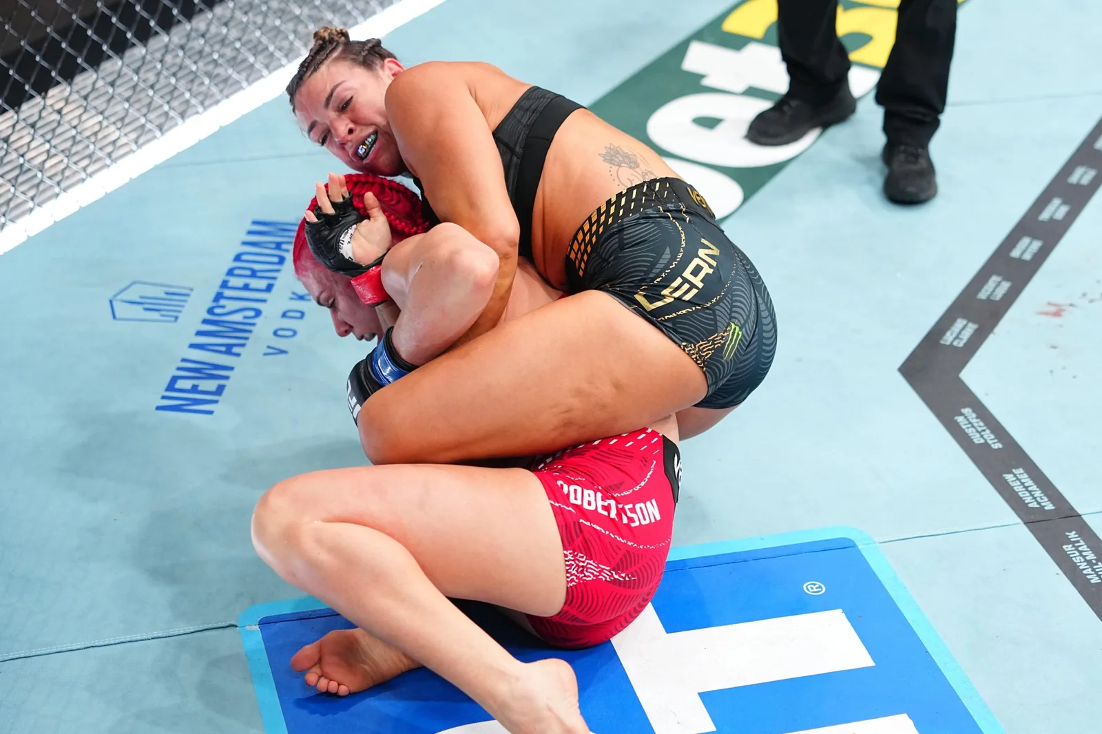 Mackenzie Dern grapples with Gillian Robertson during the UFC 330 strawweight title fight
