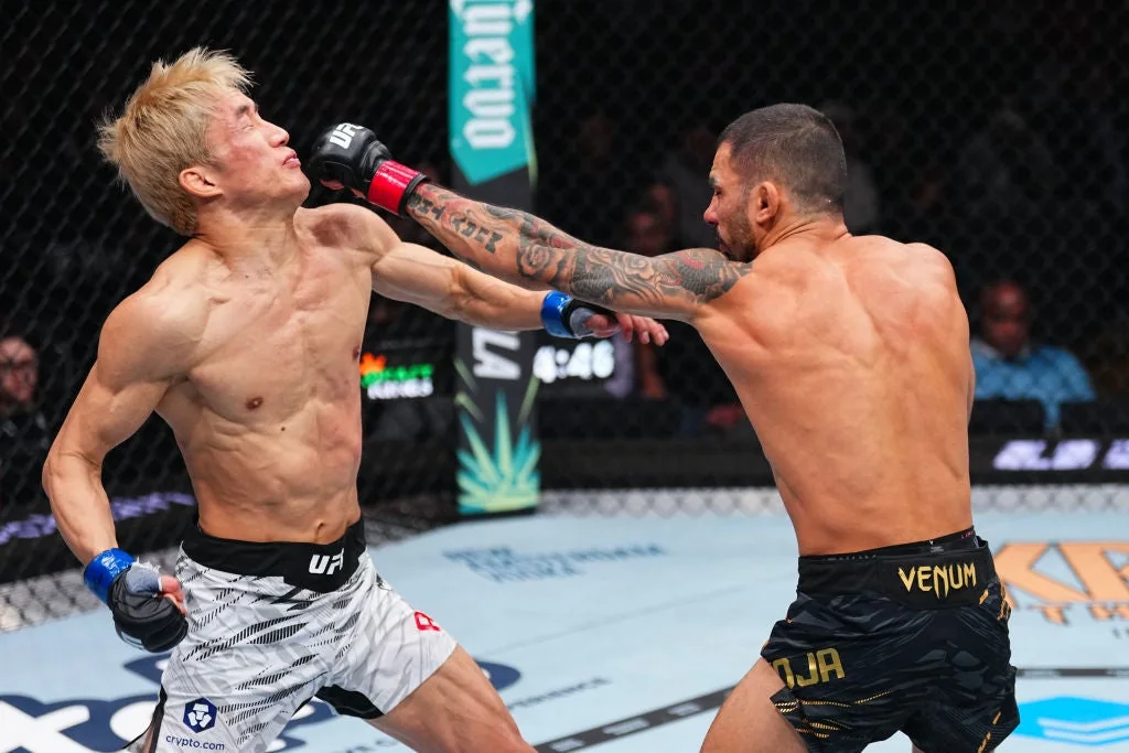 Alexandre Pantoja lands a right hand on Kai Asakura in a UFC flyweight title fight
