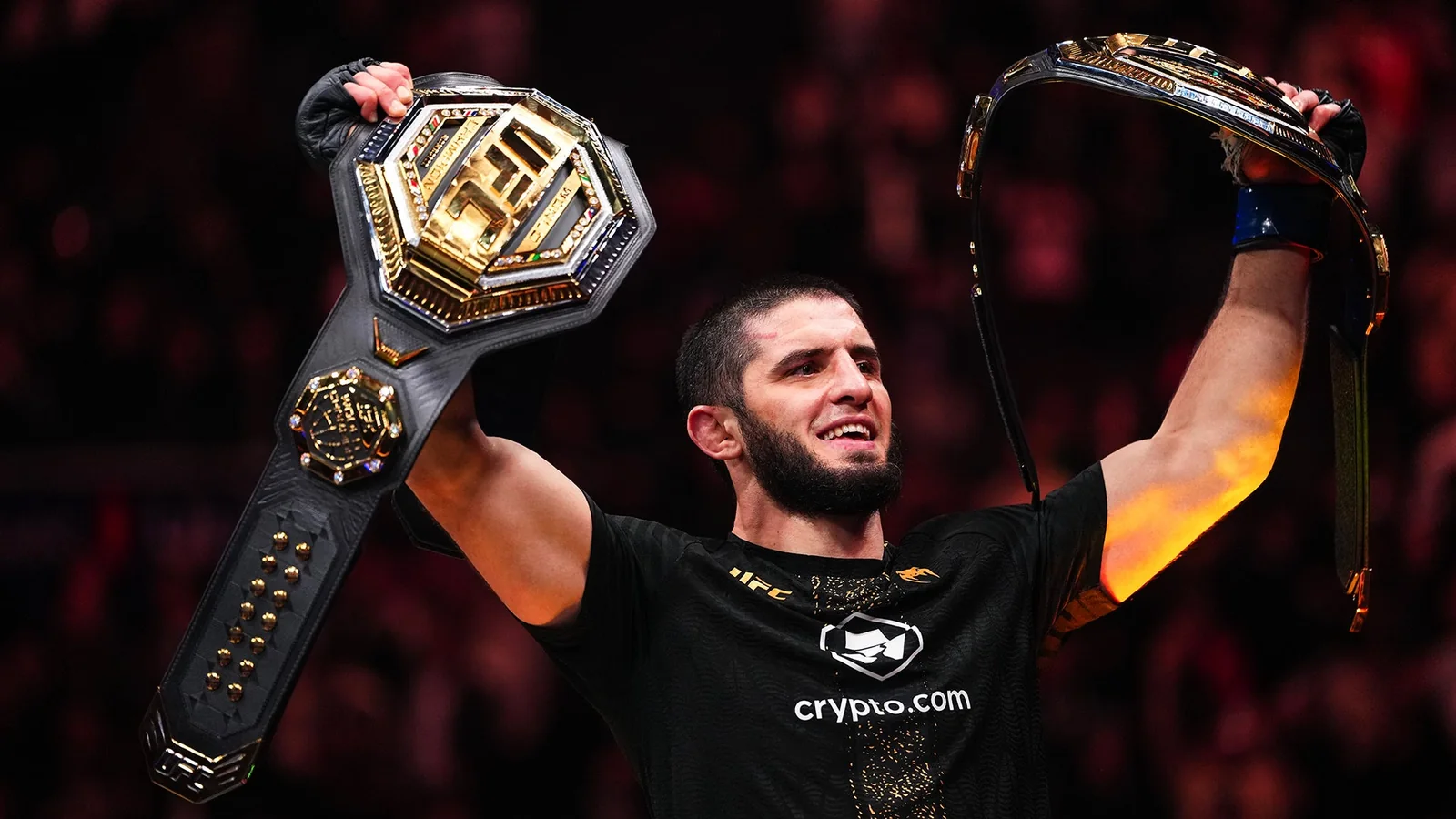 Islam Makhachev raises two UFC championship belts after winning at UFC 322